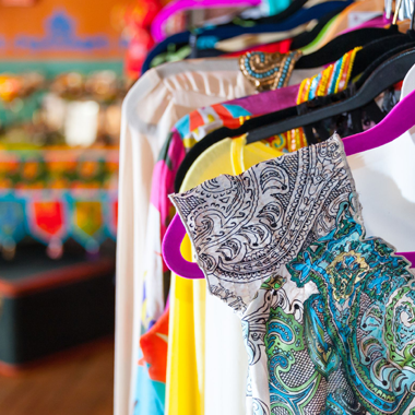 colorful women's clothing on racks in a boutique, showcasing a stunning collection